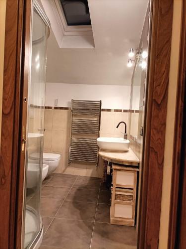 a bathroom with a sink and a tub and a toilet at Il palazzetto "fori porta" in Vitorchiano