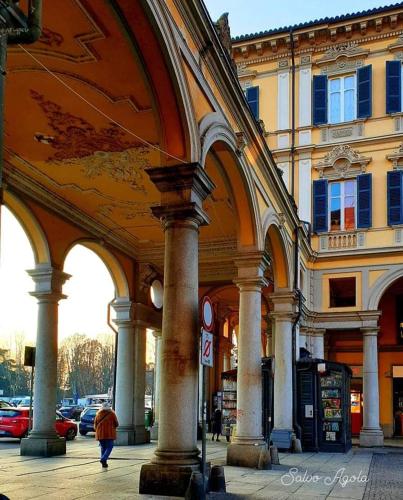 a person walking past a large building with columns at I Portici guest house in Alessandria