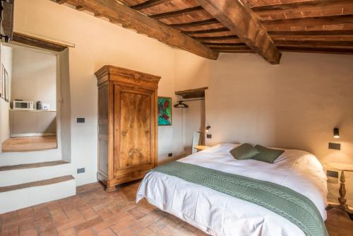 een slaapkamer met een bed in een kamer met houten plafonds bij La Porticina in Montalcino