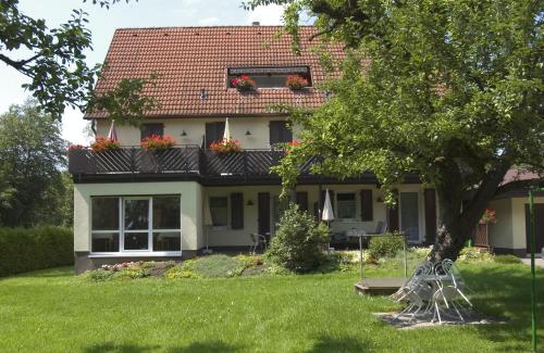 ein Haus mit einem Baum im Hof in der Unterkunft Gästehaus Mäder in Bad Dürrheim