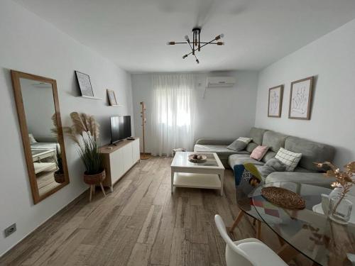 sala de estar con sofá y espejo en Apartamento ciudad jardín, en Córdoba