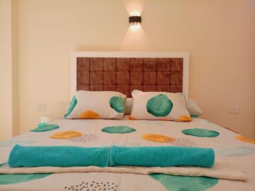 a bedroom with a large bed with blue sheets and pillows at cozy apartment Aircon Downtown Aswan in Aswan