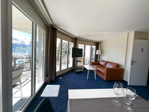 a hotel room with a couch and a view of the ocean at Seehotel Riviera at Lake Lucerne in Gersau