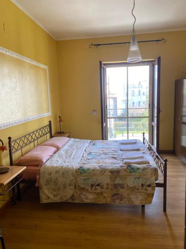 a bedroom with a bed and a large window at B&B Lucius in Pompei