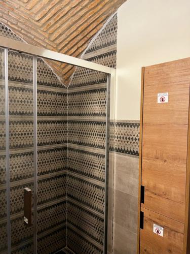 a walk in closet with a wooden door and a wall at Consolación17 in Cáceres