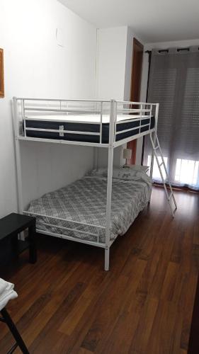 a bunk bed in a room with a wooden floor at Apartamento Ibañez Martín in Mora de Rubielos