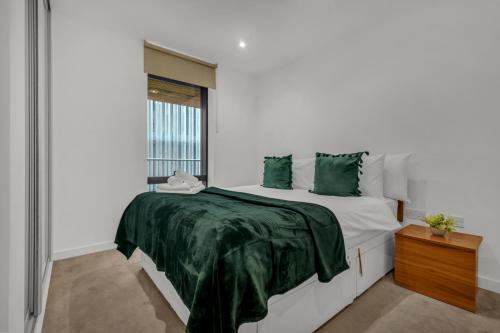 Un dormitorio con una cama con almohadas verdes y una ventana en Modern One Bedroom Apartments in Old Street en Londres
