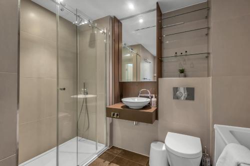 y baño con ducha, aseo y lavamanos. en Modern One Bedroom Apartments in Old Street en Londres