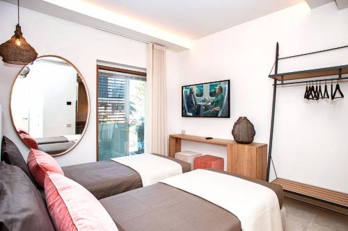 a bedroom with two beds and a mirror at Vistamare Suite & Room in Marina di Campo