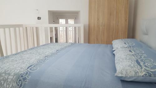 een bed met een blauw dekbed in een slaapkamer bij Casa Athena in Crotone