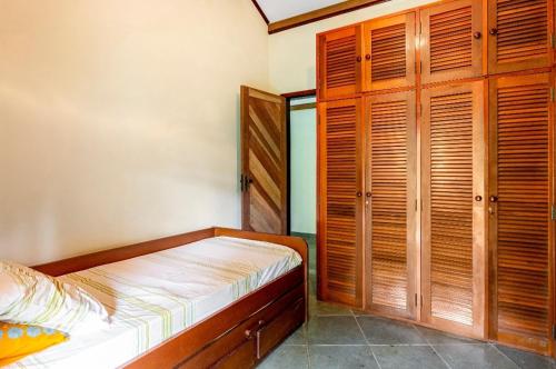 a small bedroom with a bed and wooden cabinets at Sítio Borges in Petrópolis