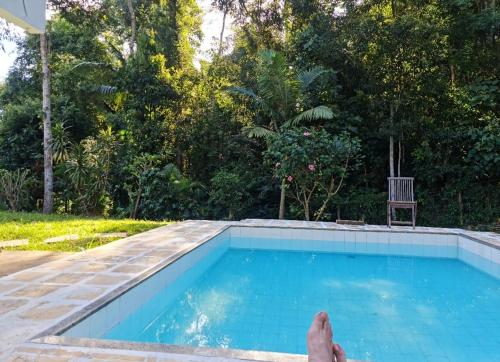 a person laying on the edge of a swimming pool at Sítio Borges in Petrópolis