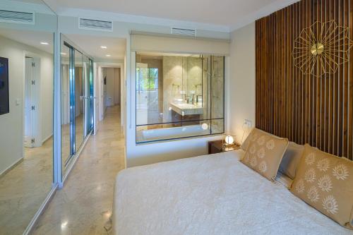 ein Schlafzimmer mit einem großen Bett und einem großen Fenster in der Unterkunft Next to Puente Romano Newly done Modern style 5 star Luxury stay in Marbella