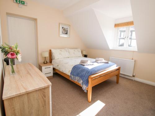 a small bedroom with a bed and a window at The Wynnstead Annexe in West Felton