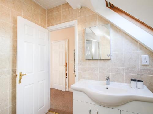 a bathroom with a sink and a mirror at The Wynnstead Annexe in West Felton