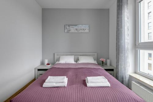 a bedroom with a large bed with two towels on it at Bastion View TriApart in Gdańsk