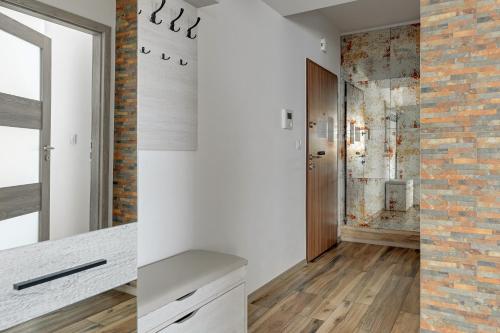 a bathroom with white walls and a brick wall at Bastion View TriApart in Gdańsk