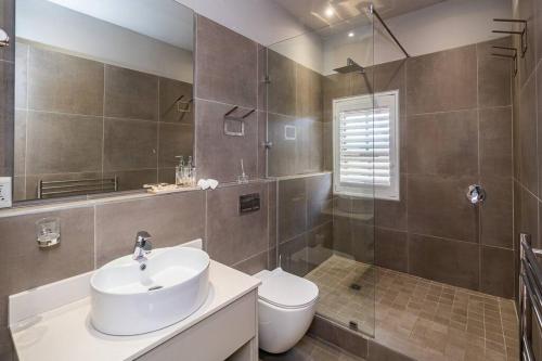 a bathroom with a white sink and a toilet at *Self-Check in - Whale Watching Paradise -Central* in Hermanus
