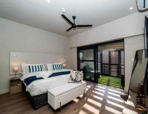 a bedroom with a white bed and a white couch at *Self-Check in - Whale Watching Paradise -Central* in Hermanus