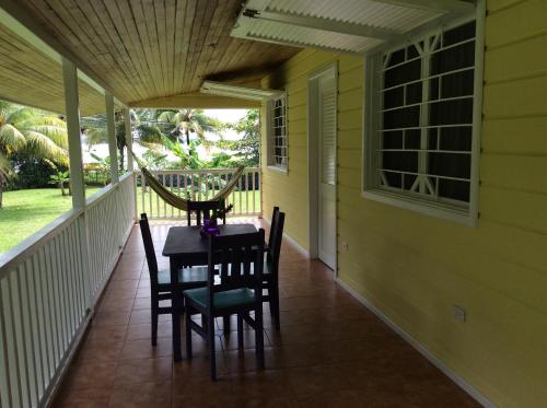 a porch with a table and chairs on it at Sand Dollar Beach Bed & Breakfast in Bocas del Toro