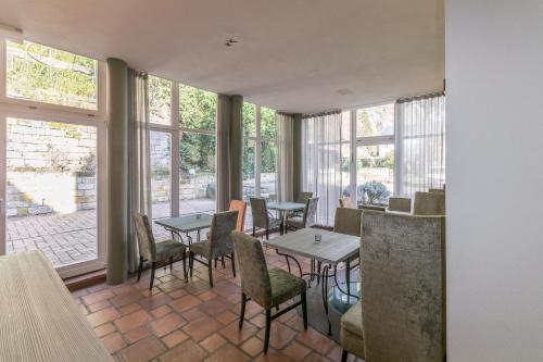 un comedor con mesas, sillas y ventanas en Albergo-Toscana en Bad Schandau