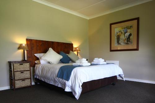 a bedroom with a large bed with towels on it at Rohrs Farm Guesthouse in Piet Retief