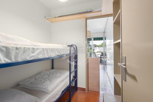 Cette chambre comprend 2 lits superposés et un couloir. dans l'établissement AS22429 - P2 Cabine avec terrasse et jardin privatif, au Grau-du-Roi