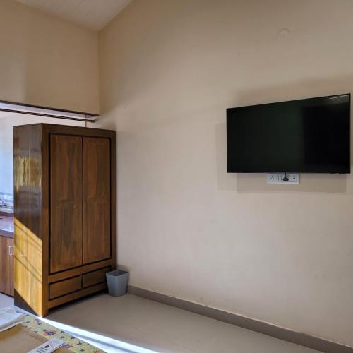 a room with a flat screen tv on a wall at The Riverstone Agro Farm in Vajapūr