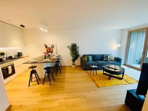 ein Wohnzimmer mit einem blauen Sofa und einem Tisch in der Unterkunft Luxury Brand New Flat with Terrace & Parking - RTL1 in Luxemburg (Stadt)
