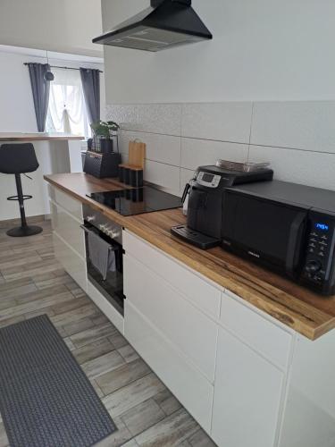 a kitchen with a microwave on a counter at Villa Anna, ingyenes Wifivel és parkolással. in Zalaegerszeg