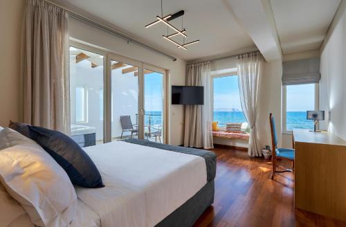 um quarto com uma cama e vista para o oceano em Rodo Seafront Villa with private pool and jacuzzis by Volta Suites and Villas em Kokkíni Khánion