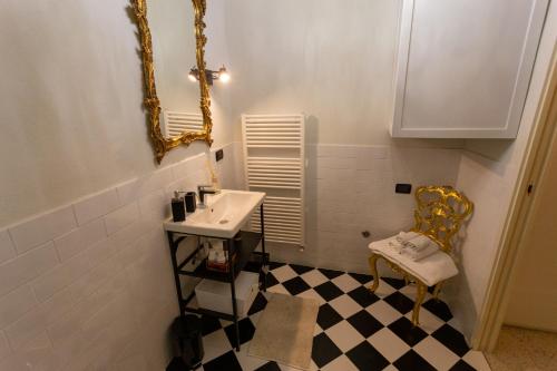 La salle de bains est pourvue d'un lavabo, d'un miroir et d'une chaise. dans l'établissement a casa di Ale, à Lucques