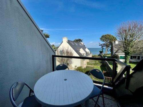 d'un balcon avec une table et des chaises blanches donnant sur l'océan. dans l'établissement Appartement bord de mer à Saint-Pierre-Quiberon avec balcon et garage - FR-1-478-181, à Saint-Pierre-Quiberon