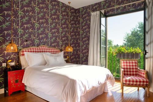 a bedroom with a bed and a large window at A Quinta Da Auga Hotel Spa Relais & Chateaux in Santiago de Compostela