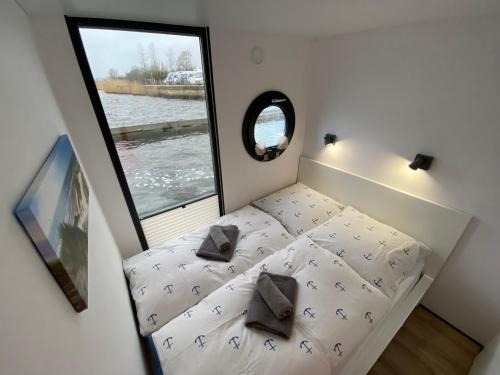 a small bed in a small room with a window at Hausboot Claudia Schleswig in Schleswig