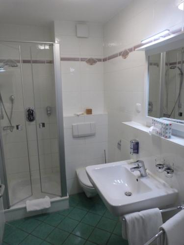 a bathroom with a sink and a shower and a toilet at ankerplatz-Hotel garni in Wilhelmshaven