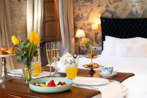 a breakfast table in a hotel room with a bowl of fruit at A Quinta Da Auga Hotel Spa Relais & Chateaux in Santiago de Compostela