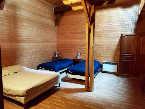 2 camas en una habitación con paredes de madera en Appartement de 3 chambres avec piscine partagee jardin amenage et wifi a Blaignac, en Blaignac
