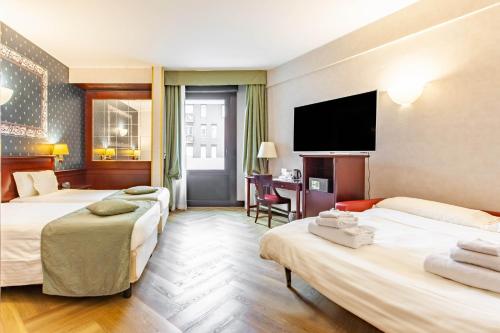 a hotel room with two beds and a flat screen tv at HOTIDAY Hotel Milano Turro in Milan