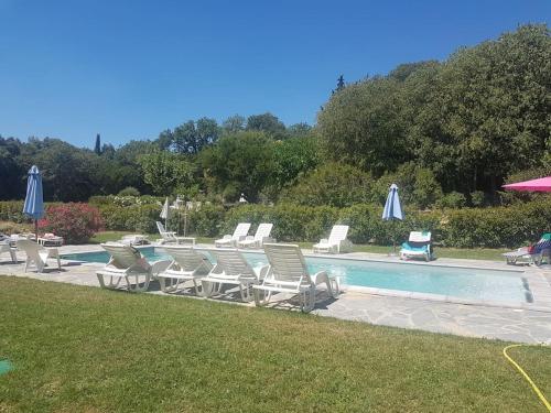 un grupo de sillas y sombrillas junto a una piscina en grand gîte de charme en Cévennes, en Fressac