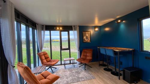 een woonkamer met blauwe muren en een tafel en stoelen bij Vakantiehuis Maria Louise in Franeker