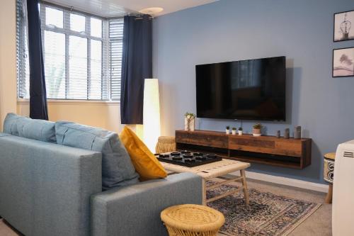 a living room with a blue couch and a tv at Spacious Apartment -Double and Sofabed -Wonderful Royal Pavilion Views in Brighton & Hove