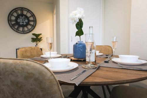 a dining room table with white dishes and a blue vase at Spacious Apartment -Double and Sofabed -Wonderful Royal Pavilion Views in Brighton & Hove