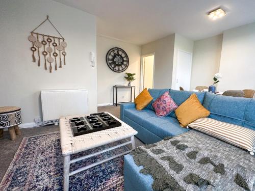 een woonkamer met een blauwe bank en een tafel bij Wonderful Pavilion View 1BR by Sullivan Stays in Brighton & Hove