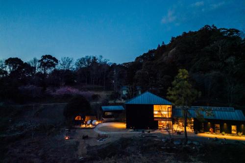 a building with a blue roof at night at HARUKA KANATA 森のヴィラ in Minamiboso
