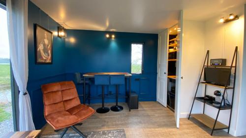 Zimmer mit einer blauen Wand mit einem Tisch und einem Stuhl in der Unterkunft Vakantiehuis Maria Louise in Franeker