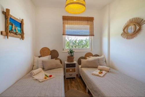 um quarto com duas camas e uma janela em Fairyland Villa 150qm für 8pax em Paljuv