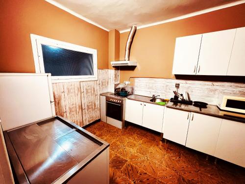 cocina con armarios blancos, fregadero y ventana en Alojamiento Camino Portugues, en Porriño