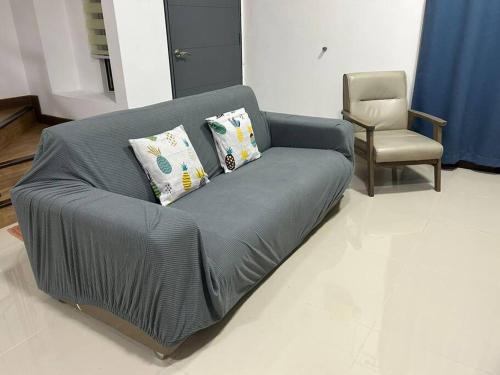 a couch with two pillows and a chair in a room at 69 S2 Heights, Ainsdale # U Homestay in Seremban