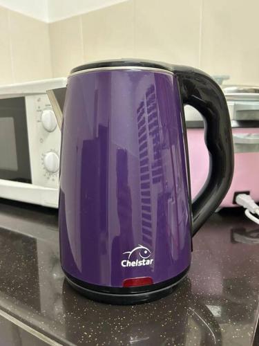 a purple coffee cup sitting on a kitchen counter at 69 S2 Heights, Ainsdale # U Homestay in Seremban